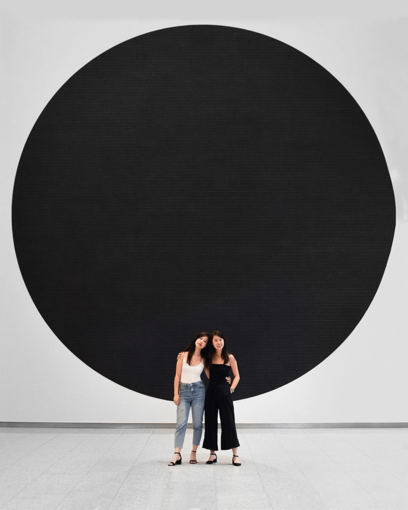 Lori and her sister in front of a circle background